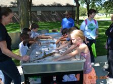Children are playing with a river model activity.