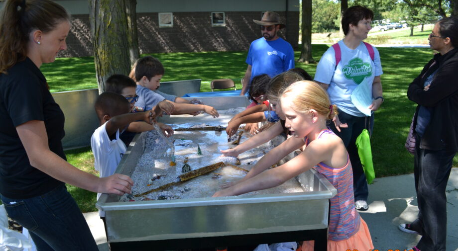 Children are playing with a river model activity.